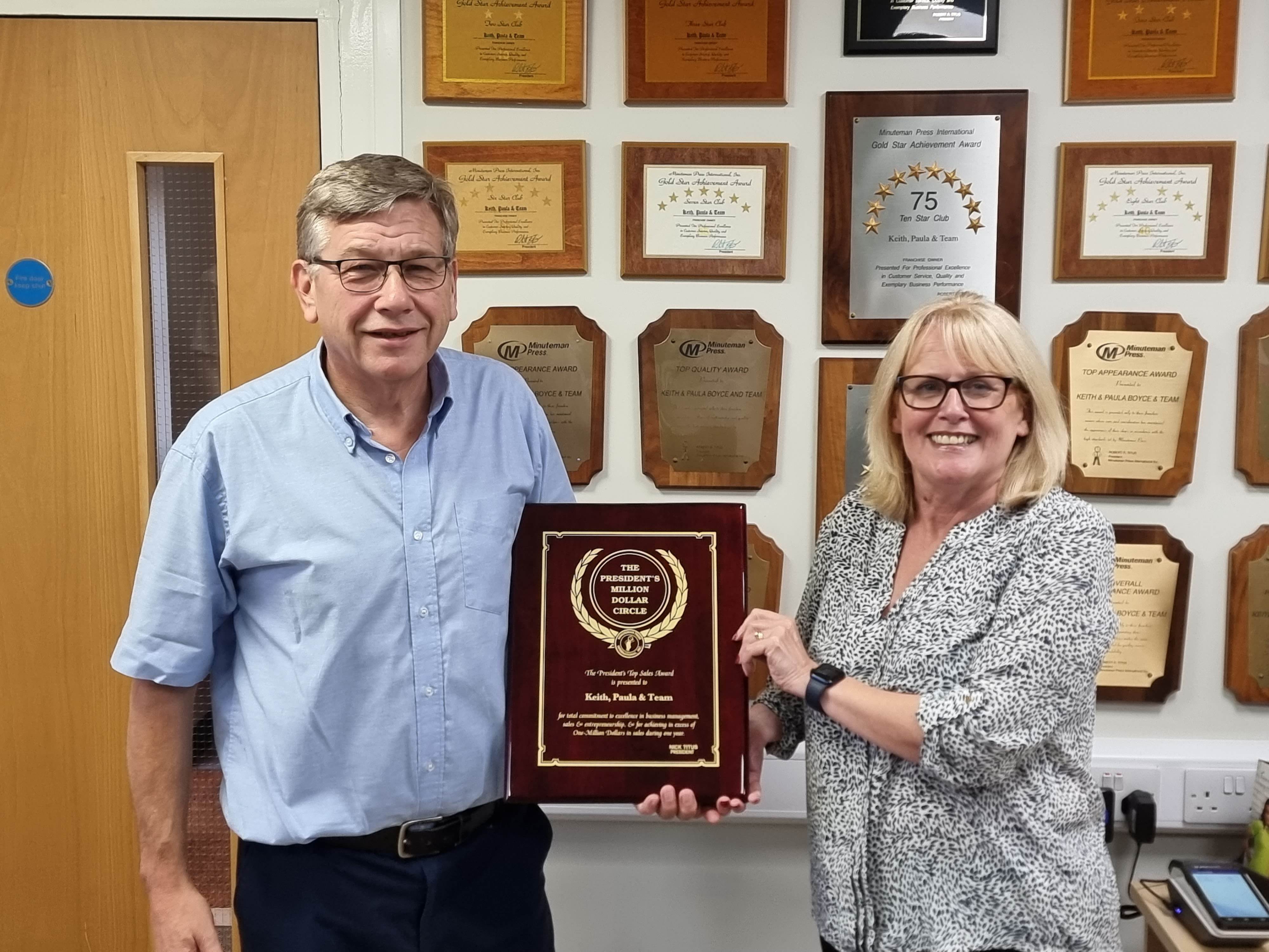 Minuteman Press franchise owners Keith and Paula Boyce with their President’s Club plaque at their centre in King’s Lynn, England.
